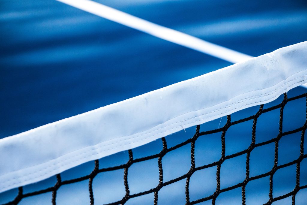Tennis net with blue court background